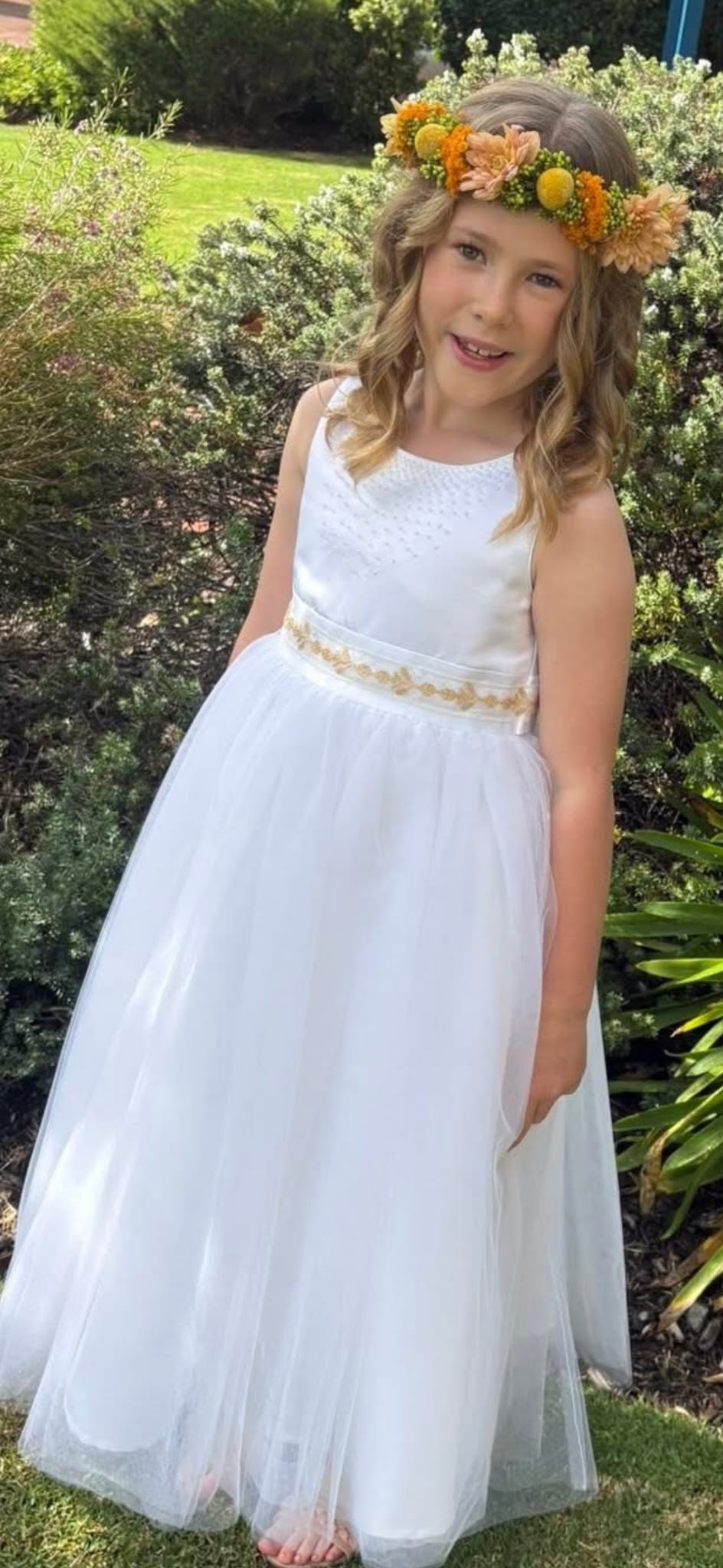 A young girl in a white dress outdoors