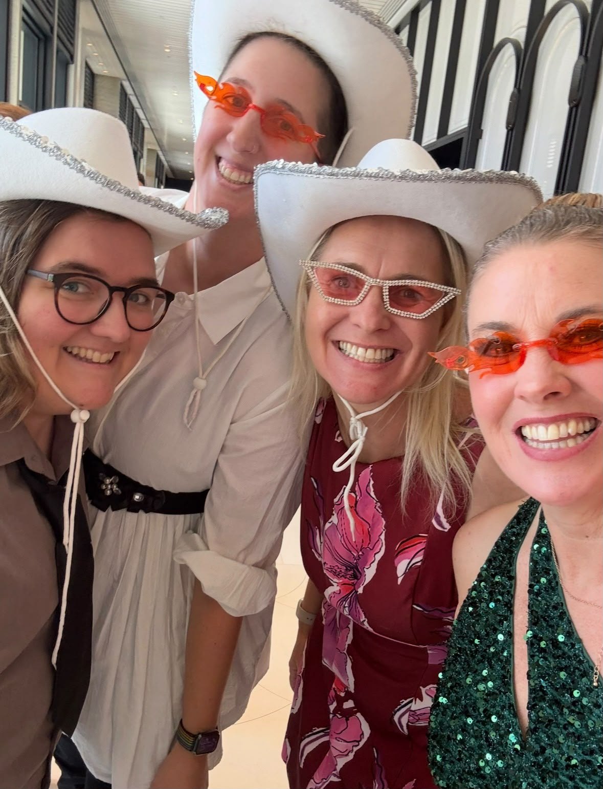 Anne-Marie laughing with friends in hats